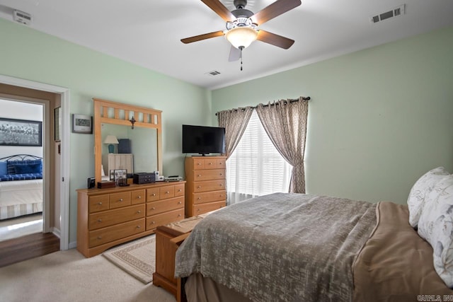 carpeted bedroom featuring visible vents and ceiling fan