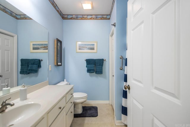 bathroom featuring baseboards, vanity, and toilet