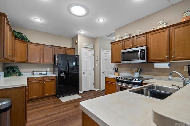 kitchen with dark wood finished floors, light countertops, visible vents, a sink, and appliances with stainless steel finishes