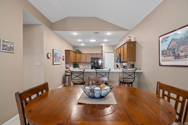 dining area featuring vaulted ceiling
