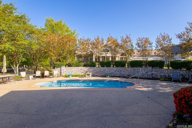 view of swimming pool featuring a patio area, a fenced in pool, and fence