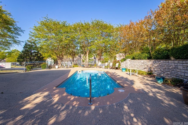 pool featuring fence and a patio