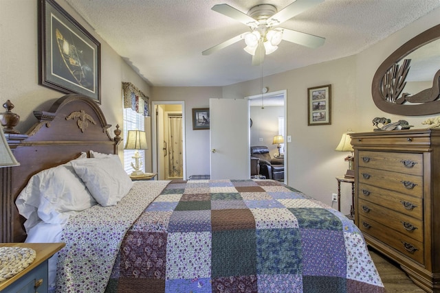 bedroom with ceiling fan, wood finished floors, and a textured ceiling