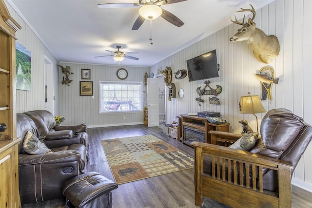 living room with baseboards, wood finished floors, ceiling fan, and crown molding