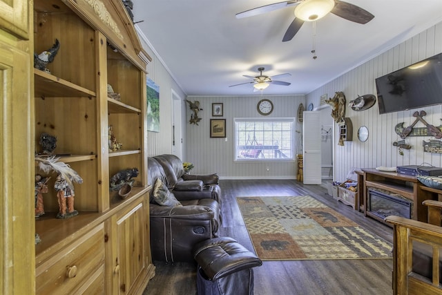 living room with crown molding, wood finished floors, a ceiling fan, and baseboards