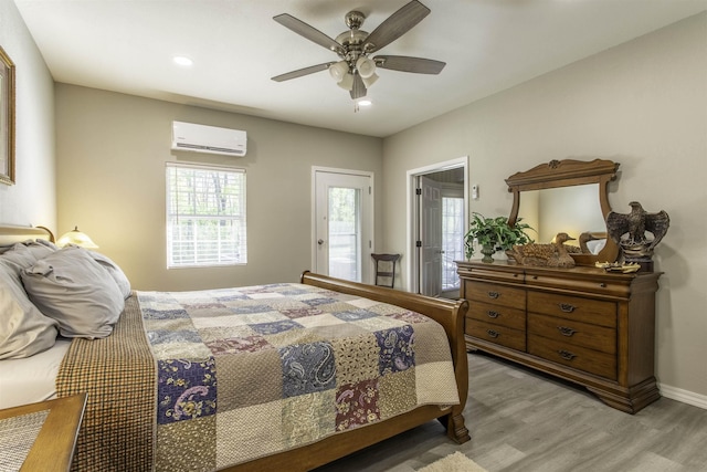 bedroom with recessed lighting, light wood-type flooring, an AC wall unit, and multiple windows