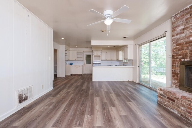 309 Del Rio Dr, Little Rock, AR 72205 - unfurnished living room with ceiling fan, visible vents, a fireplace, baseboards, and dark wood-style floors