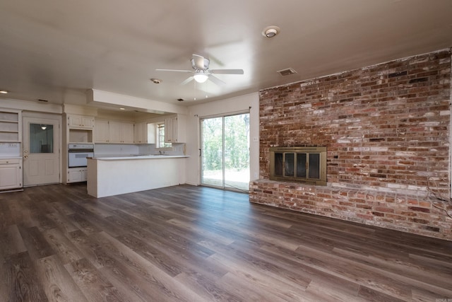 309 Del Rio Dr, Little Rock, AR 72205 - unfurnished living room with a ceiling fan, visible vents, a fireplace, and dark wood-style flooring