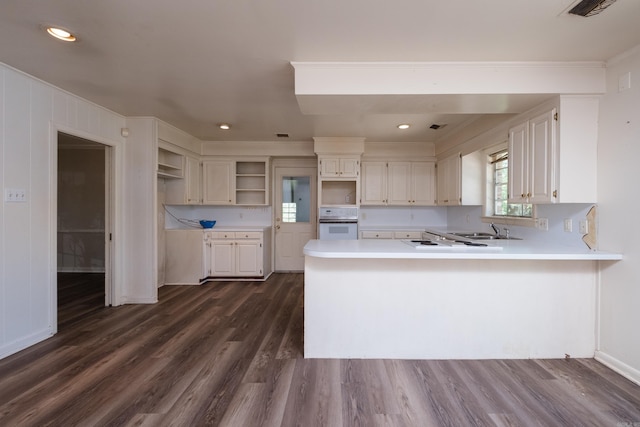 309 Del Rio Dr, Little Rock, AR 72205 - kitchen with open shelves, a sink, oven, dark wood finished floors, and a peninsula