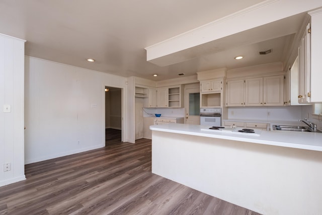 309 Del Rio Dr, Little Rock, AR 72205 - kitchen featuring open shelves, a sink, white appliances, dark wood finished floors, and a peninsula
