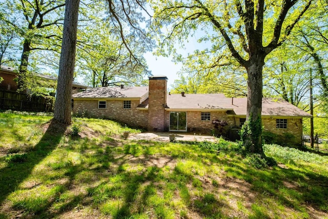 309 Del Rio Dr, Little Rock, AR 72205 - rear view of house featuring fence, a chimney, brick siding, and a patio