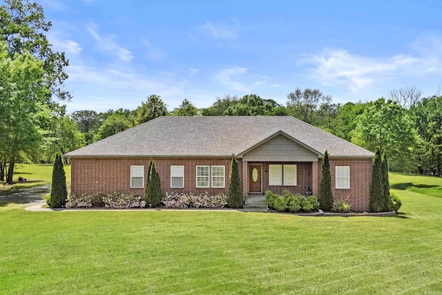 single story home featuring brick siding, a shingled roof, and a front yard