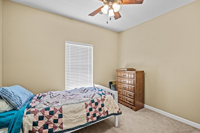 carpeted bedroom with a ceiling fan and baseboards