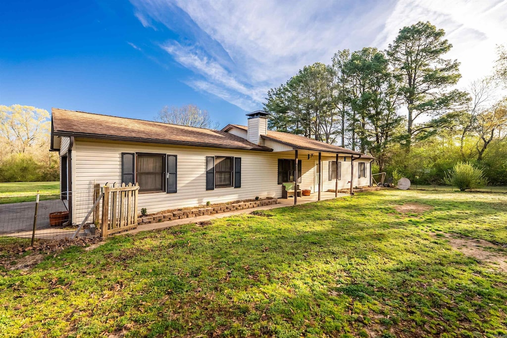 2002 W Maddox Rd, Jacksonville, AR 72076 - back of house with a yard, a chimney, and a patio