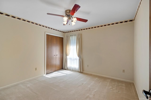 unfurnished room featuring a ceiling fan, baseboards, and light carpet