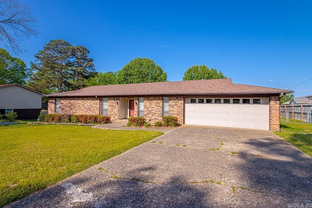 ranch-style home featuring an attached garage, brick siding, a front yard, and concrete driveway