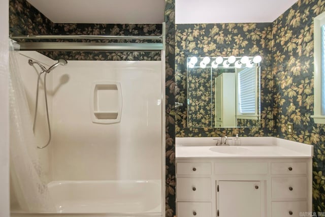 bathroom with shower / bathing tub combination, wallpapered walls, and vanity