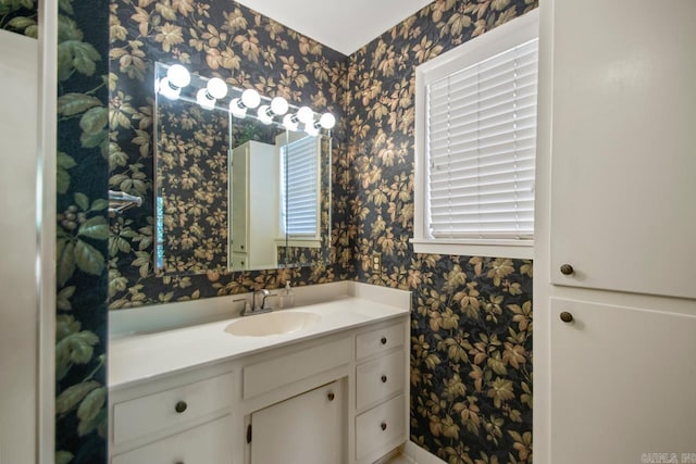 bathroom featuring vanity and wallpapered walls