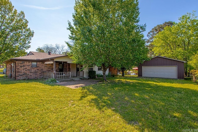 view of front of property featuring a porch, an outbuilding, a front yard, and a garage