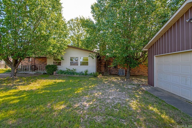 view of front of house featuring central AC, a front lawn, and a garage