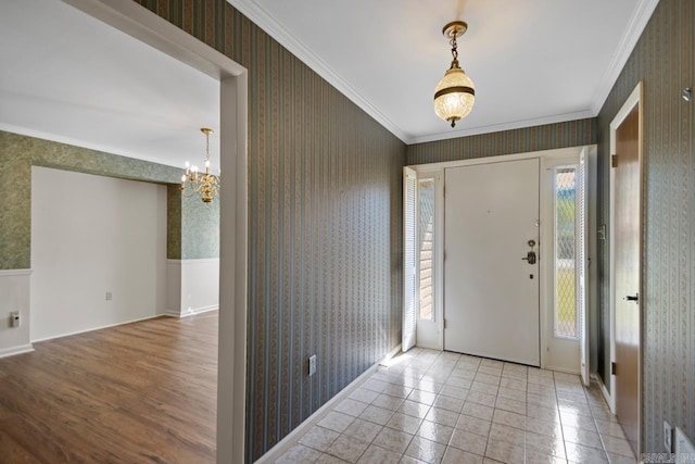 foyer featuring wallpapered walls, an inviting chandelier, and ornamental molding