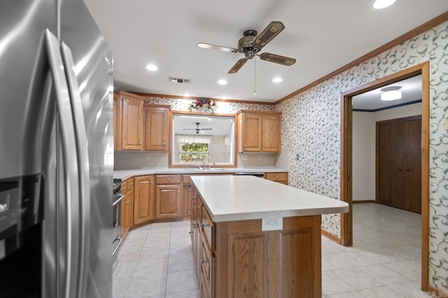 kitchen with light countertops, visible vents, a ceiling fan, crown molding, and appliances with stainless steel finishes