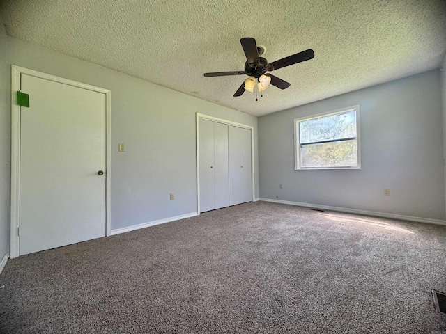 unfurnished bedroom featuring baseboards, a closet, a textured ceiling, and carpet