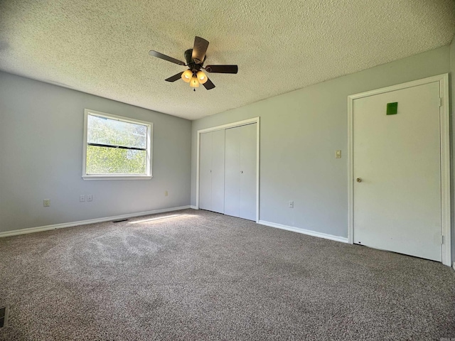unfurnished bedroom featuring carpet, a ceiling fan, a closet, baseboards, and a textured ceiling