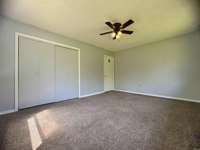 unfurnished bedroom featuring a textured ceiling, a closet, carpet flooring, and baseboards