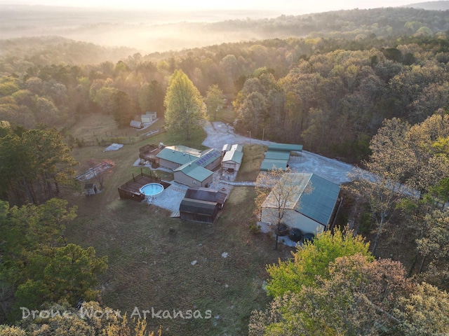 drone / aerial view with a wooded view