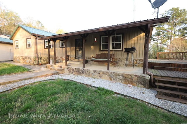 single story home featuring a wooden deck and metal roof
