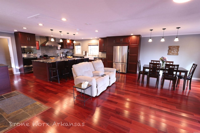 living area with recessed lighting, dark wood finished floors, and ornamental molding
