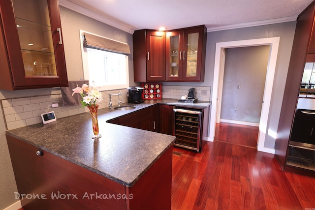 kitchen featuring crown molding, a sink, decorative backsplash, beverage cooler, and dark wood finished floors