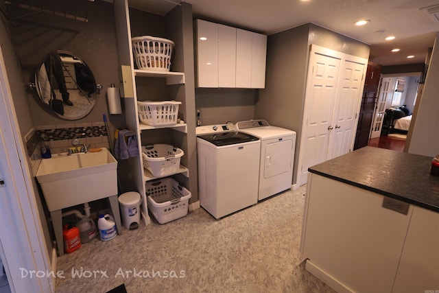 washroom featuring cabinet space, washing machine and clothes dryer, recessed lighting, and a sink