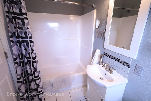 bathroom with tile patterned flooring, backsplash, a textured wall, vanity, and shower / bath combo with shower curtain