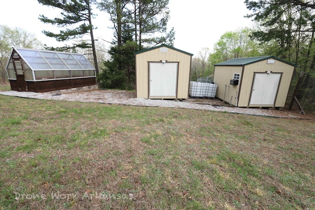 view of greenhouse featuring a storage unit and a lawn