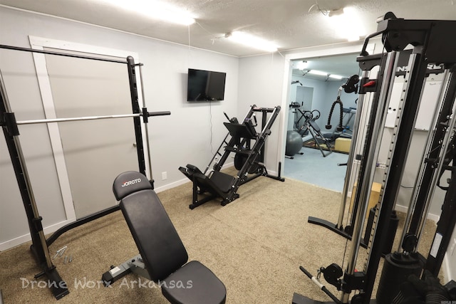 workout area with baseboards and a textured ceiling