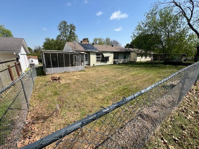 view of yard featuring a sunroom and a fenced backyard