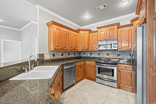 kitchen featuring a sink, visible vents, backsplash, crown molding, and appliances with stainless steel finishes