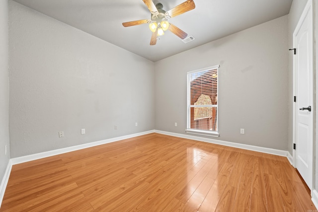 unfurnished room featuring vaulted ceiling, a ceiling fan, light wood-style flooring, baseboards, and visible vents