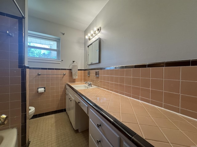 21 Belmont Dr, Little Rock, AR 72204 - bathroom with a wainscoted wall, toilet, tile walls, tile patterned flooring, and vanity