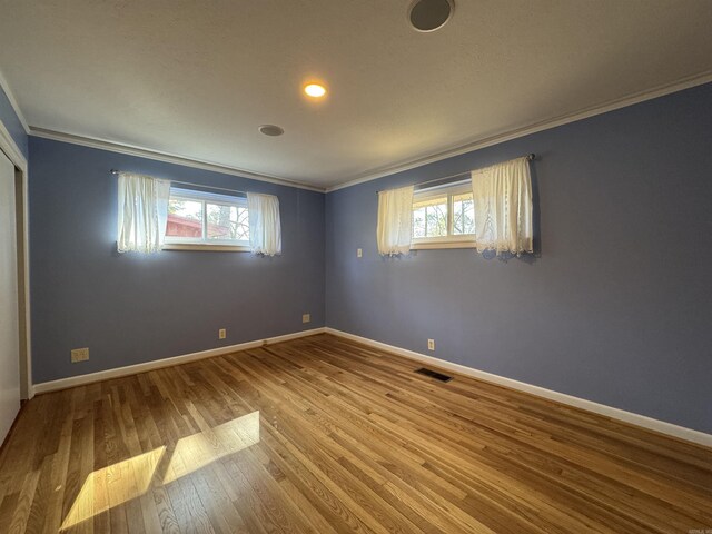 21 Belmont Dr, Little Rock, AR 72204 - unfurnished bedroom featuring multiple windows, wood finished floors, visible vents, and ornamental molding
