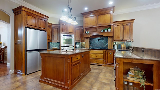 kitchen featuring stainless steel appliances, a sink, arched walkways, dark stone counters, and decorative backsplash