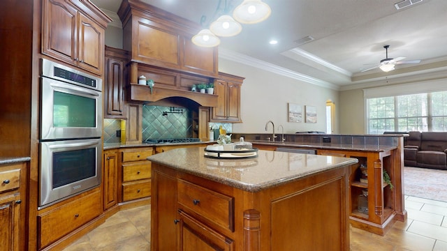 kitchen featuring stainless steel appliances, a peninsula, a ceiling fan, a kitchen island, and light tile patterned floors