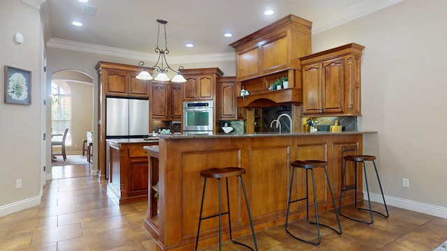 kitchen with stainless steel appliances, visible vents, arched walkways, a peninsula, and tasteful backsplash