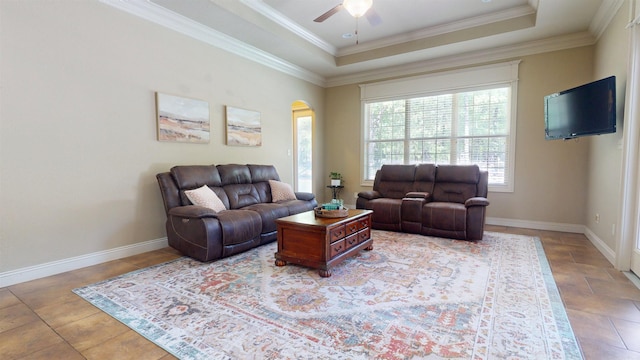 living room featuring arched walkways, a ceiling fan, crown molding, and a raised ceiling