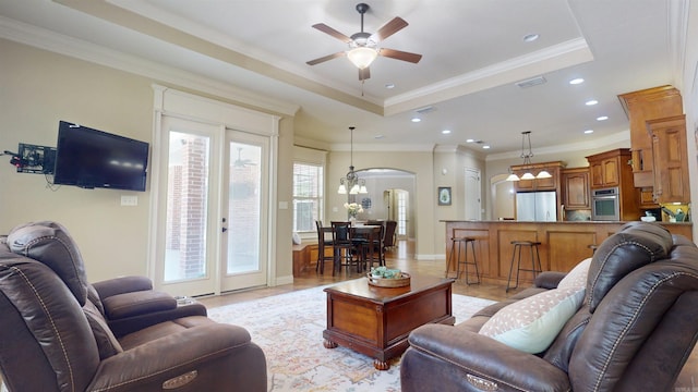 living area with recessed lighting, a raised ceiling, ornamental molding, arched walkways, and ceiling fan