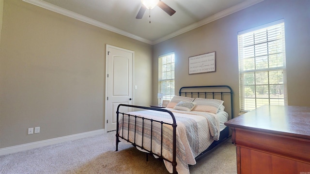 bedroom featuring a ceiling fan, baseboards, light colored carpet, and crown molding