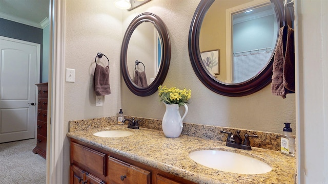 full bath featuring crown molding, a sink, and double vanity