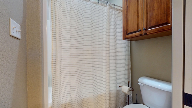 full bathroom with a bathing tub, curtained shower, and toilet